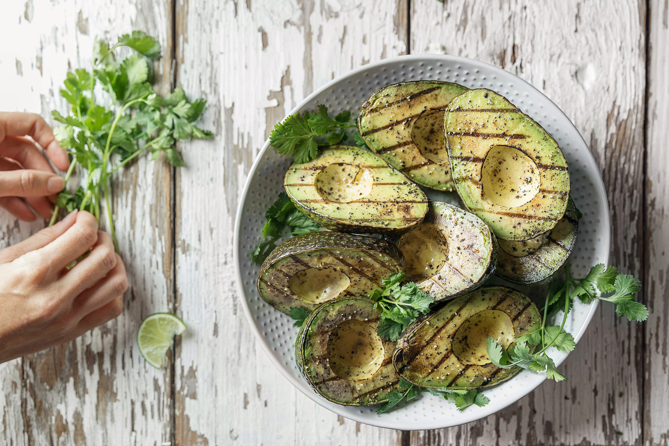 Glanger Photography | Halved Grilled Avocados with hands placing cilantro and lime
