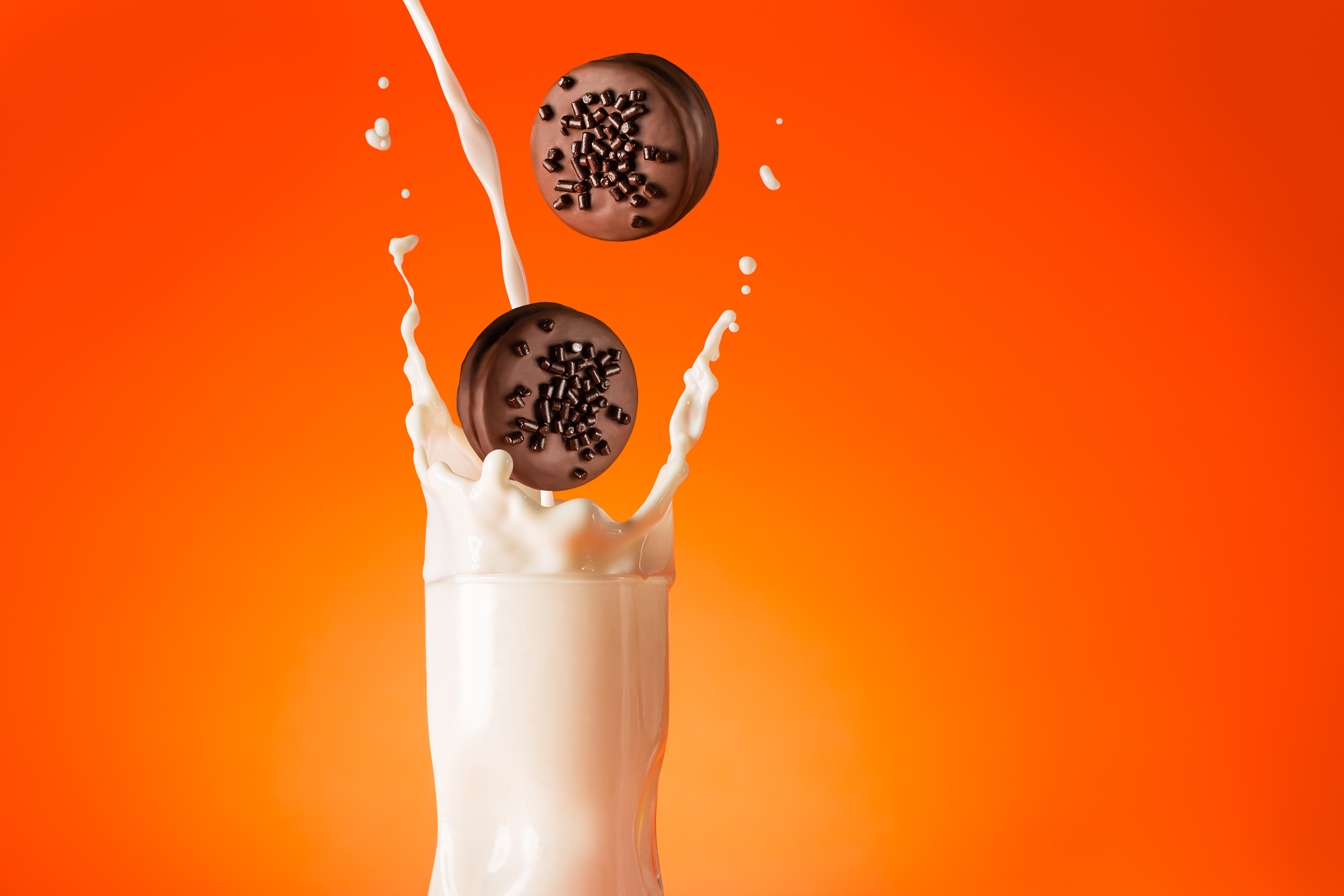 Glanger Photography | Southern Cocktails, Orange, LiquorMarinela Gansito cookies dropping into splashing milk w orange background