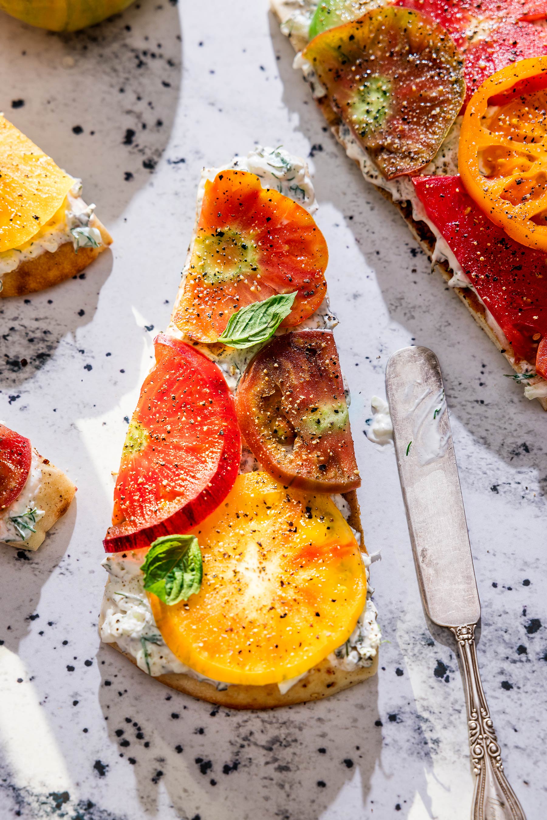Glanger Photography | Close up of Heirloom tomatoes on toast with tzatziki sauce shot overhead.