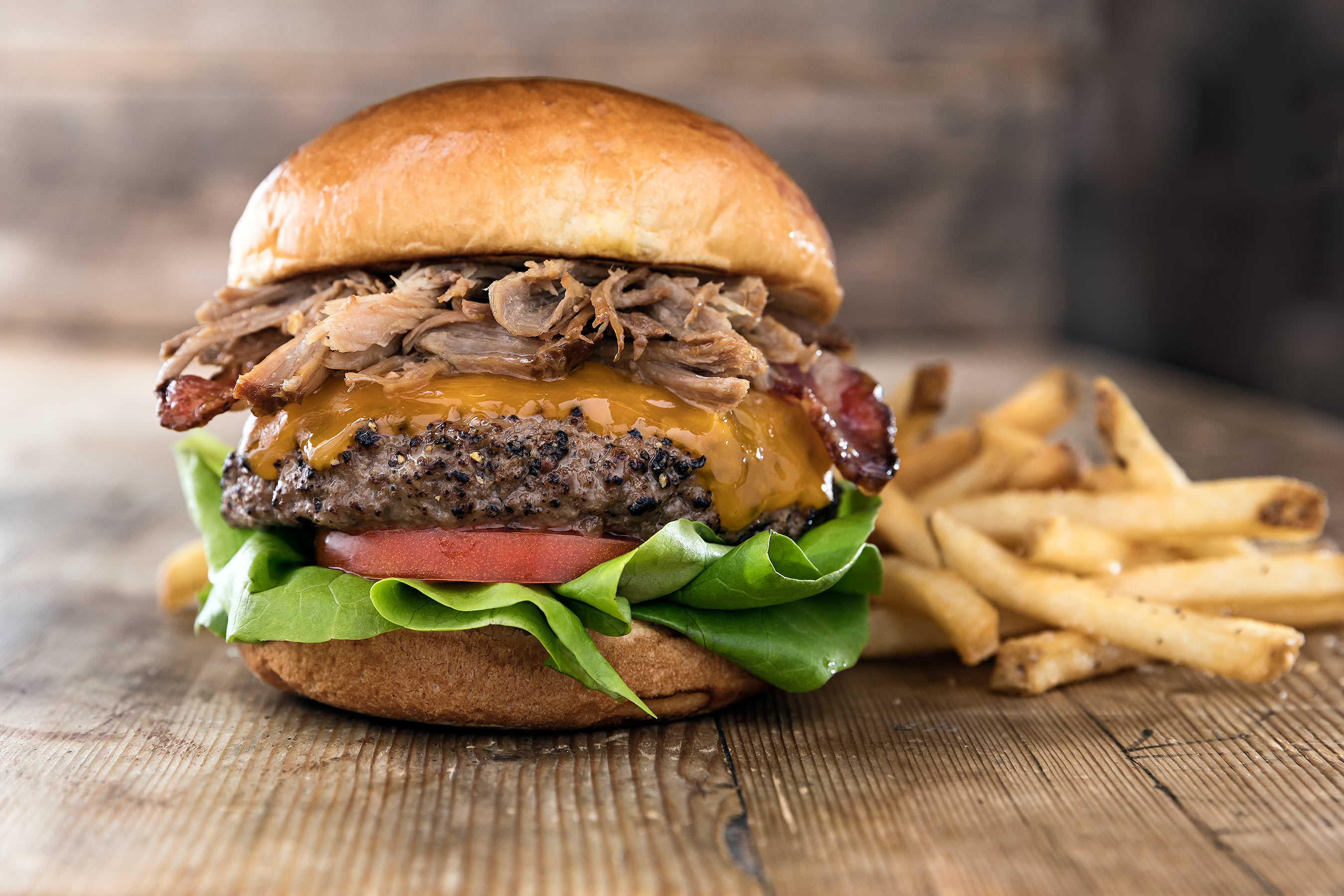 BBQ CHIPOTLE BURGER with pulled pork, cheddar, bacon, lettuce & tomato