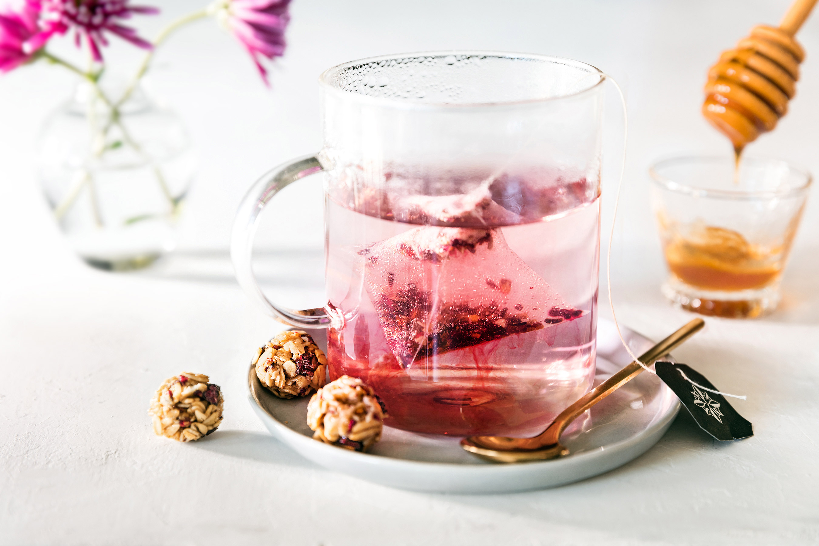Glanger Photography | Glass of Herbal Tea with Granola Bites + honey on white with bright lighting